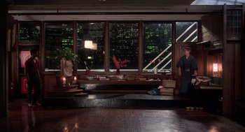 Movie still from “The Last Dragon” (1985), directed by Michael Schultz – A man standing in front of a window at night; Wide shot, Over the shoulder angle