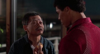 Movie still from “The Last Dragon” (1985), directed by Michael Schultz – An older man and a younger man are talking to each other; Close Up shot, Over the shoulder angle