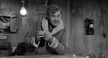 Movie still from “The Last Picture Show” (1971), directed by Peter Bogdanovich – A black and white photo of a man knitting; Medium shot, Over the shoulder angle