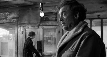 Movie still from “The Last Picture Show” (1971), directed by Peter Bogdanovich – A man and a woman standing in front of a building; Medium shot, Over the shoulder angle