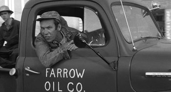 Movie still from “The Last Picture Show” (1971), directed by Peter Bogdanovich – An old photo of a man sitting in the drivers seat of an old truck; Medium shot, Over the shoulder angle