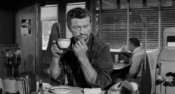 Movie still from “The Last Picture Show” (1971), directed by Peter Bogdanovich – A black and white photo of a man holding a cup of coffee; Close Up shot, Over the shoulder angle