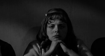 Movie still from “The Last Picture Show” (1971), directed by Peter Bogdanovich – A woman sitting in a chair with her hands under her chin; Close Up shot, High angle