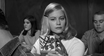 Movie still from “The Last Picture Show” (1971), directed by Peter Bogdanovich – A young woman holding up a small painting while another woman looks on; Close Up shot, Over the shoulder angle