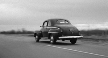 Movie still from “The Last Picture Show” (1971), directed by Peter Bogdanovich – An old car is driving down the street; Wide shot, Low angle