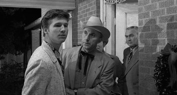 Movie still from “The Last Picture Show” (1971), directed by Peter Bogdanovich – Two men and a man in a suit and hat; Medium shot, Over the shoulder angle