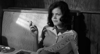 Movie still from “The Last Picture Show” (1971), directed by Peter Bogdanovich – A black and white photo of a woman smoking a cigarette; Medium shot, Low angle