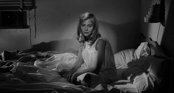 Movie still from “The Last Picture Show” (1971), directed by Peter Bogdanovich – Black and white photograph of a girl sitting on a bed; Medium shot, High angle