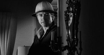 Movie still from “The Last Picture Show” (1971), directed by Peter Bogdanovich – A black and white photo of a man in a hard hat looking in a mirror; Close Up shot, Over the shoulder angle