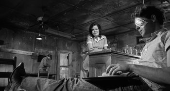 Movie still from “The Last Picture Show” (1971), directed by Peter Bogdanovich – A woman sitting at a table in a room; Medium shot, Low angle