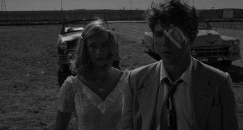 Movie still from “The Last Picture Show” (1971), directed by Peter Bogdanovich – A man and a woman standing next to each other in a field; Close Up shot, Low angle