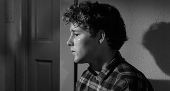 Movie still from “The Last Picture Show” (1971), directed by Peter Bogdanovich – Black and white photograph of a young man looking out a door; Close Up shot, Over the shoulder angle