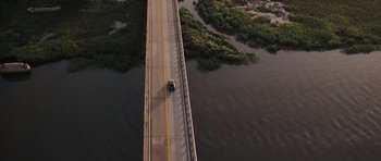 Movie still from “The Last Song” (2010), directed by Julie Anne Robinson – An aerial view of a car driving on a bridge over a river; Extreme Wide shot, Overhead angle