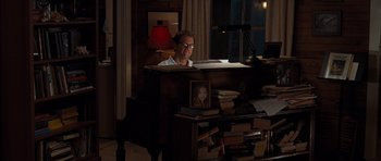 Movie still from “The Last Song” (2010), directed by Julie Anne Robinson – A man sitting at a desk in front of books; Medium shot, Over the shoulder angle