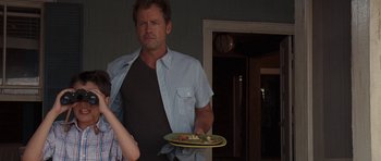 Movie still from “The Last Song” (2010), directed by Julie Anne Robinson – A man holding a plate with food on top of it; Medium shot, Over the shoulder angle