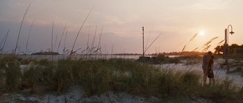 Movie still from “The Last Song” (2010), directed by Julie Anne Robinson – The sun is setting over the water and grass; Extreme Wide shot, Over the shoulder angle