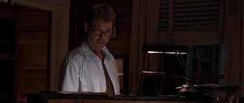 Movie still from “The Last Song” (2010), directed by Julie Anne Robinson – A man in glasses is looking at a computer screen; Medium shot, Over the shoulder angle