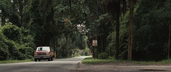 Movie still from “The Last Song” (2010), directed by Julie Anne Robinson – A truck driving down a road near trees and bushes; Extreme Wide shot, Low angle