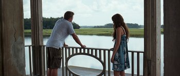 Movie still from “The Last Song” (2010), directed by Julie Anne Robinson – A man and a woman looking over a railing at a lake; Wide shot, Over the shoulder angle