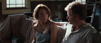 Movie still from “The Last Song” (2010), directed by Julie Anne Robinson – A man and a woman sitting on a couch talking; Medium shot, Over the shoulder angle