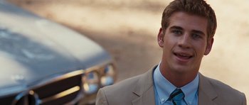 Movie still from “The Last Song” (2010), directed by Julie Anne Robinson – A man in a suit and tie standing next to a car; Close Up shot, Over the shoulder angle