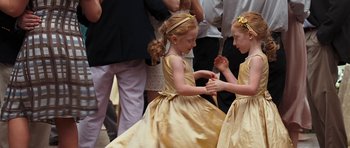 Movie still from “The Last Song” (2010), directed by Julie Anne Robinson – Two little girls dressed in gold dancing together; Close Up shot, High angle