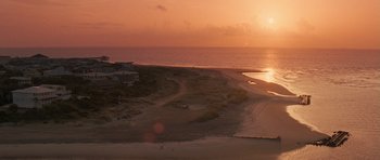 Movie still from “The Last Song” (2010), directed by Julie Anne Robinson – The sun is setting over the ocean and a beach; Extreme Wide shot, High angle