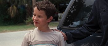 Movie still from “The Last Song” (2010), directed by Julie Anne Robinson – A young boy is being hugged by an older man; Medium shot, Over the shoulder angle