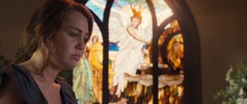 Movie still from “The Last Song” (2010), directed by Julie Anne Robinson – A woman standing in front of a stained - glass window; Medium shot, Over the shoulder angle