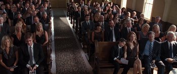 Movie still from “The Last Song” (2010), directed by Julie Anne Robinson – A group of people in suits and ties sitting in a church; Wide shot, High angle