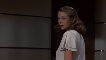 Movie still from “The Last Tycoon” (1976), directed by Elia Kazan – A woman in a white dress standing next to a wall; Close Up shot, Low angle
