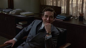 Movie still from “The Last Tycoon” (1976), directed by Elia Kazan – A man sitting in a chair with his hand under his chin; Medium shot, Low angle