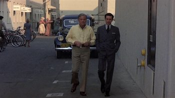 Movie still from “The Last Tycoon” (1976), directed by Elia Kazan – Two men walking down a street next to a car; Wide shot, Low angle