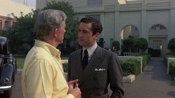Movie still from “The Last Tycoon” (1976), directed by Elia Kazan – A man in a suit talking to another man in a yellow shirt; Medium shot, Over the shoulder angle