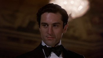 Movie still from “The Last Tycoon” (1976), directed by Elia Kazan – A person wearing a suit and bow tie; Close Up shot, Low angle