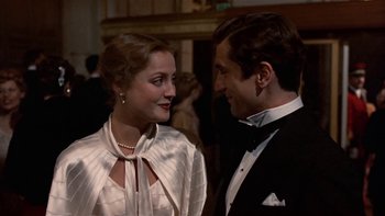 Movie still from “The Last Tycoon” (1976), directed by Elia Kazan – A man and a woman in formal wear at a party; Close Up shot, Over the shoulder angle