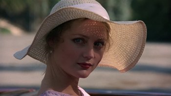 Movie still from “The Last Tycoon” (1976), directed by Elia Kazan – A woman wearing a white hat sitting in a car; Close Up shot, Over the shoulder angle