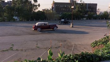 Movie still from “The Last Tycoon” (1976), directed by Elia Kazan – Two cars are driving down the street in a parking lot; Extreme Wide shot, High angle