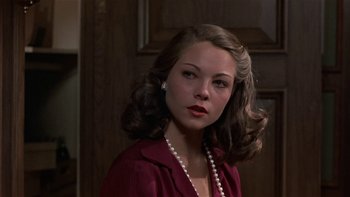 Movie still from “The Last Tycoon” (1976), directed by Elia Kazan – A woman with a pearl necklace and a red shirt; Close Up shot, Over the shoulder angle