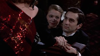 Movie still from “The Last Tycoon” (1976), directed by Elia Kazan – A man and a woman sitting next to each other at an event; Close Up shot, Over the shoulder angle