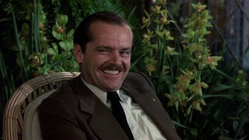 Movie still from “The Last Tycoon” (1976), directed by Elia Kazan – A man in a suit and tie smiling for the camera; Close Up shot, Low angle
