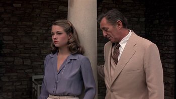 Movie still from “The Last Tycoon” (1976), directed by Elia Kazan – A man and a woman standing next to each other near a pillar; Medium shot, Over the shoulder angle