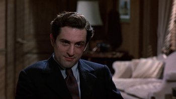 Movie still from “The Last Tycoon” (1976), directed by Elia Kazan – A person wearing a suit and tie; Close Up shot, Over the shoulder angle