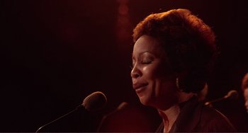 Movie still from “The Last Waltz” (1978), directed by Martin Scorsese – An older woman standing in front of a microphone; Close Up shot, Low angle