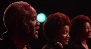 Movie still from “The Last Waltz” (1978), directed by Martin Scorsese – A man and a woman singing into microphones; Close Up shot, Low angle