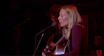 Movie still from “The Last Waltz” (1978), directed by Martin Scorsese – A woman singing into a microphone at a concert; Medium shot, Low angle