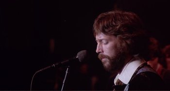 Movie still from “The Last Waltz” (1978), directed by Martin Scorsese – A man with a beard is singing into a microphone; Close Up shot, Low angle