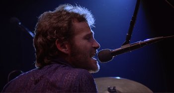 Movie still from “The Last Waltz” (1978), directed by Martin Scorsese – A man singing into a microphone at a concert; Close Up shot, Low angle