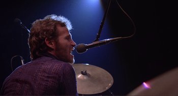 Movie still from “The Last Waltz” (1978), directed by Martin Scorsese – A man with a beard and a microphone in front of him; Close Up shot, Low angle