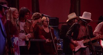 Movie still from “The Last Waltz” (1978), directed by Martin Scorsese – A group of people that are standing around a stage; Wide shot, Low angle